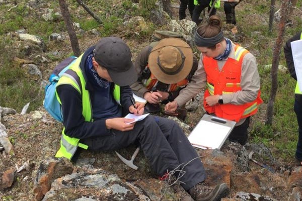 Three student geologists in the field