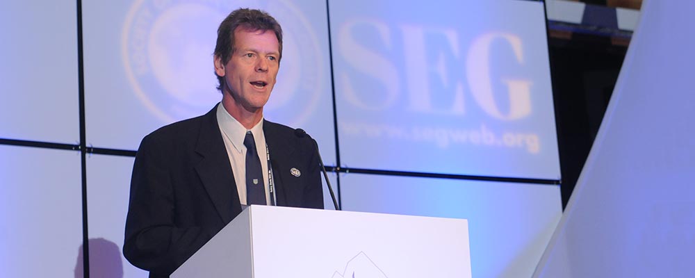 Jeremy Richards behind a podium speaking at an SEG conference
